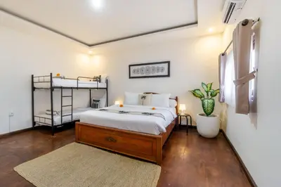 a bedroom with a bed and a plant in it at Villa Simara in Seminyak