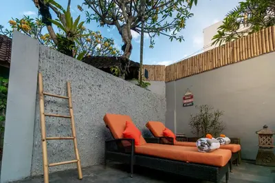 an orange couch with orange pillows and a ladder at Villa Simara in Seminyak
