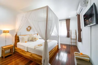 a bedroom with a bed with a canopy at Villa Putri Mila in Seminyak