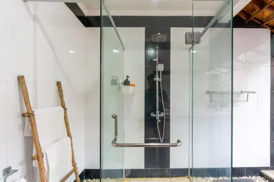 a shower with a glass door in a bathroom at Villa Putri Mila in Seminyak