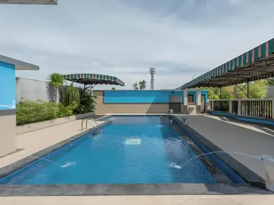 a swimming pool in front of a building at The Kanjeng Suites Kuta Galeria - Bali in Kuta