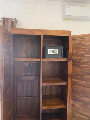 a wooden book shelf with a radio in it at Manis Guest House in Seminyak