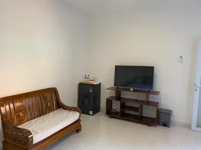 a living room with a bed and a tv at Manis Guest House in Seminyak