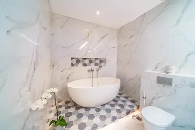 a bathroom with a white tub and a toilet at Villa Blue Water by GORO in Seminyak