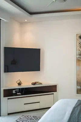 a bedroom with a television on a wall at Villa Blue Water by GORO in Seminyak