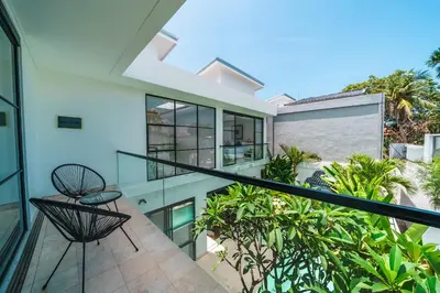 an indoor balcony of a house with a glass railing at Villa Blue Water by GORO in Seminyak