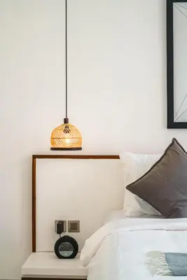 a bedroom with a bed with a clock and a lamp at Villa Blue Water by GORO in Seminyak