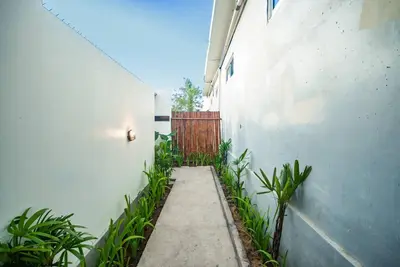 an alley with a gate and plants in front of a building at Villa Semangka, Seminyak Umalas in Kerobokan