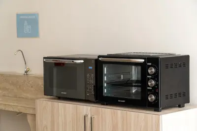 two microwaves sitting on top of a counter at Bali Bustle Pararaton Coliving and Coworking Space in Legian