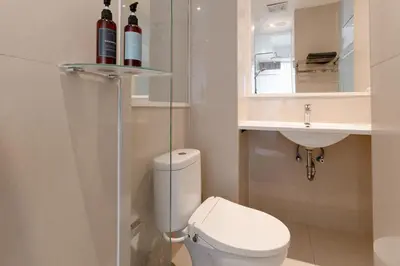 a bathroom with a white toilet and a sink at Bali Bustle Pararaton Coliving and Coworking Space in Legian