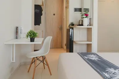 a bedroom with a bed and a chair and a table at Bali Bustle Pararaton Coliving and Coworking Space in Legian