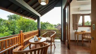 a room with a balcony with a table and chairs at Villa Alami by Villa Finder in Seminyak