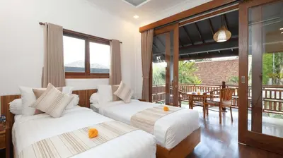 two beds in a room with a balcony at Villa Alami by Villa Finder in Seminyak