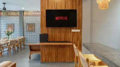 a restaurant with a tv on a wooden wall at Villa Alami by Villa Finder in Seminyak