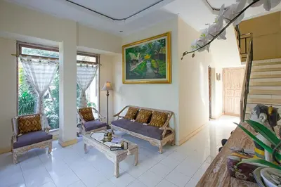 a living room with two chairs and a couch and a table at Villa Chandra in Seminyak
