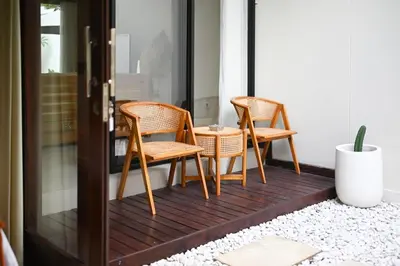 a porch with two chairs and a table at Villa bella wilson II in Seminyak