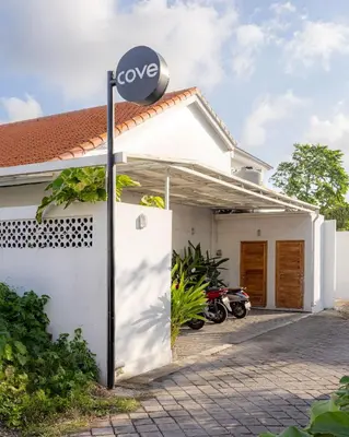a sign on the side of a white house at Cove Lotus Lofts Seminyak in Seminyak