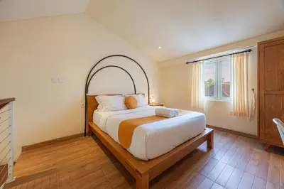 a bedroom with a large bed with a wooden frame at Cove Lotus Lofts Seminyak in Seminyak