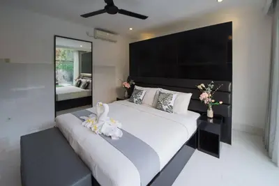 a bedroom with a large white bed with a black headboard at 7to8BR 40 off special Brilliant Location in Seminyak