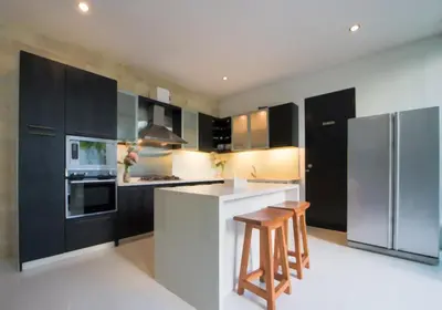 a kitchen with black cabinets and a white counter top at 7to8BR 40 off special Brilliant Location in Seminyak