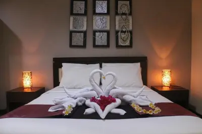 two swans made out of towels on a bed at Mansu Hotel and Spa Legian in Kuta