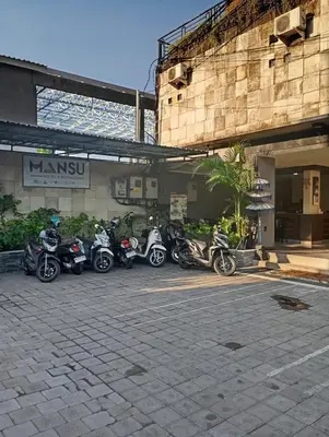 a row of motorcycles parked in front of a building at Mansu Hotel and Spa Legian in Kuta