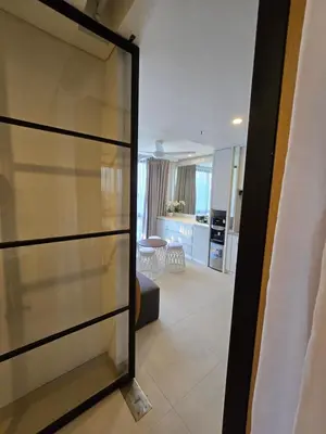 a sliding glass door leading into a living room at de' Asasta Apartment Benoa N508 in Nusa Dua