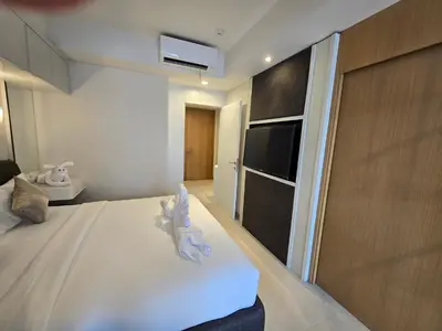 a living room with a bed and a tv and a room at de' Asasta Apartment Benoa N508 in Nusa Dua