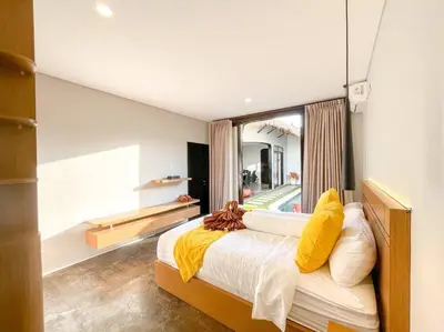 a bedroom with a bed with yellow pillows and a window at Villa Raaadha 3BR modern design villa center of seminyak in Seminyak
