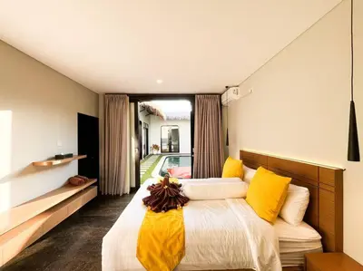 a bedroom with a large bed with yellow pillows at Villa Raaadha 3BR modern design villa center of seminyak in Seminyak