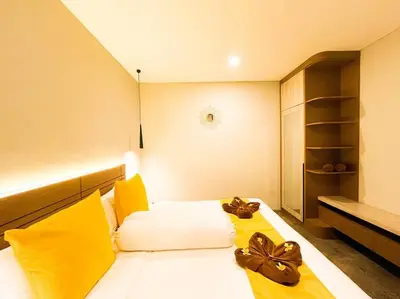 a bedroom with a large bed with yellow pillows at Villa Raaadha 3BR modern design villa center of seminyak in Seminyak