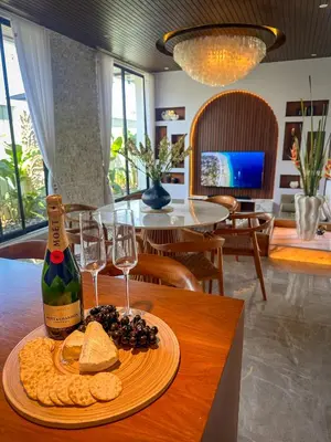 a table with a plate of crackers and a bottle of wine at Nococu Luxury Villa in Seminyak