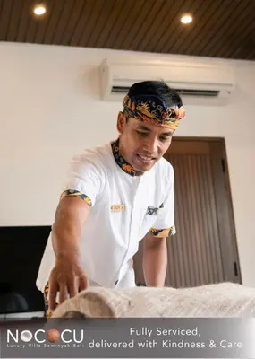 a young man in a kitchen preparing food at Nococu Luxury Villa in Seminyak