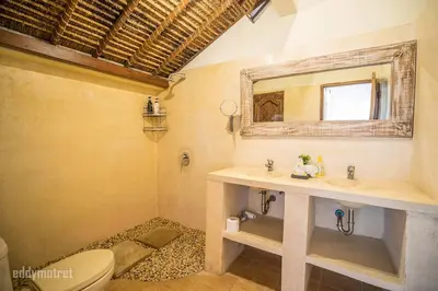 a bathroom with a sink and a toilet and a mirror at Tropical 3BR villa in the heart of Seminyak in Seminyak
