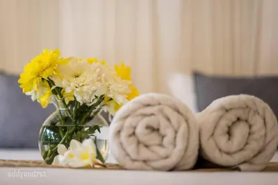 a vase of flowers and towels on a table at Tropical 3BR villa in the heart of Seminyak in Seminyak