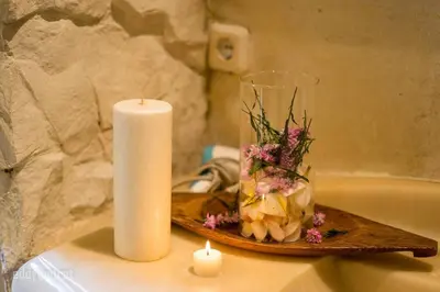 a candle and a vase with flowers on a table at Tropical 3BR villa in the heart of Seminyak in Seminyak
