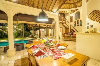 a dining room with a table and a pool at Tropical 3BR villa in the heart of Seminyak in Seminyak