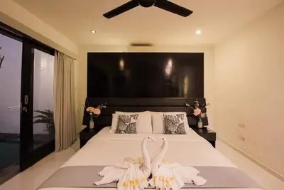 a bedroom with a bed with white sheets and flowers at 20 off Special Brilliant Location in Seminyak