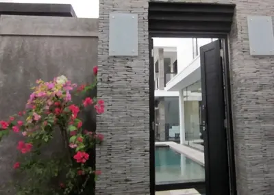 a door to a building with flowers and a pool at 20 off Special Brilliant Location in Seminyak