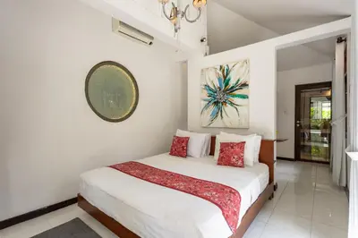 a white bedroom with a bed with red pillows at 3 BR Villa in d' centre Seminyak in Seminyak