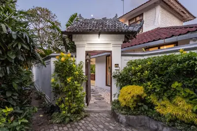 a white house with a gate and a walkway at 3 BR Villa in d' centre Seminyak in Seminyak