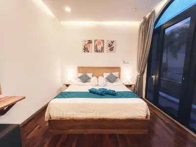 a bedroom with a bed and a large window at Villa Paros 3BR Greek Island Villa in Seminyak in Seminyak