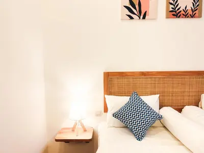 a bedroom with a bed with a blue and white pillow at Villa Paros 3BR Greek Island Villa in Seminyak in Seminyak