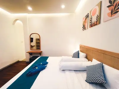 a bedroom with a large white bed with blue pillows at Villa Paros 3BR Greek Island Villa in Seminyak in Seminyak