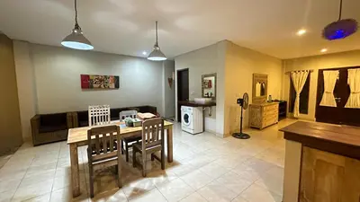 a kitchen and living room with a table and chairs at Taman Giri House 3 Bedrooms Nusa Dua in Nusa Dua