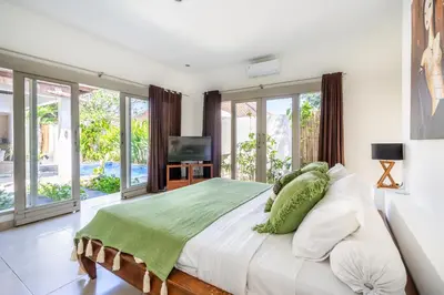 a bedroom with a large bed and a television at Zen Villas by iBali Management in Kerobokan