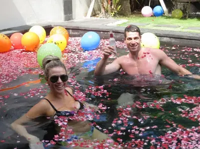 a man and a woman in a pool covered in confetti at Villa True Colors in Legian