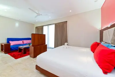 a bedroom with a white bed and a blue couch at Villa True Colors in Legian