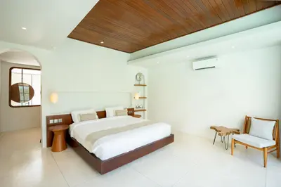 a bedroom with a bed and a desk and a chair at Green Jimbaran Bay Villa III in Jimbaran