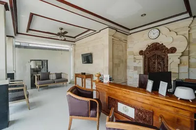 a lobby with a desk and a clock on the wall at You Suite Seminyak in Legian